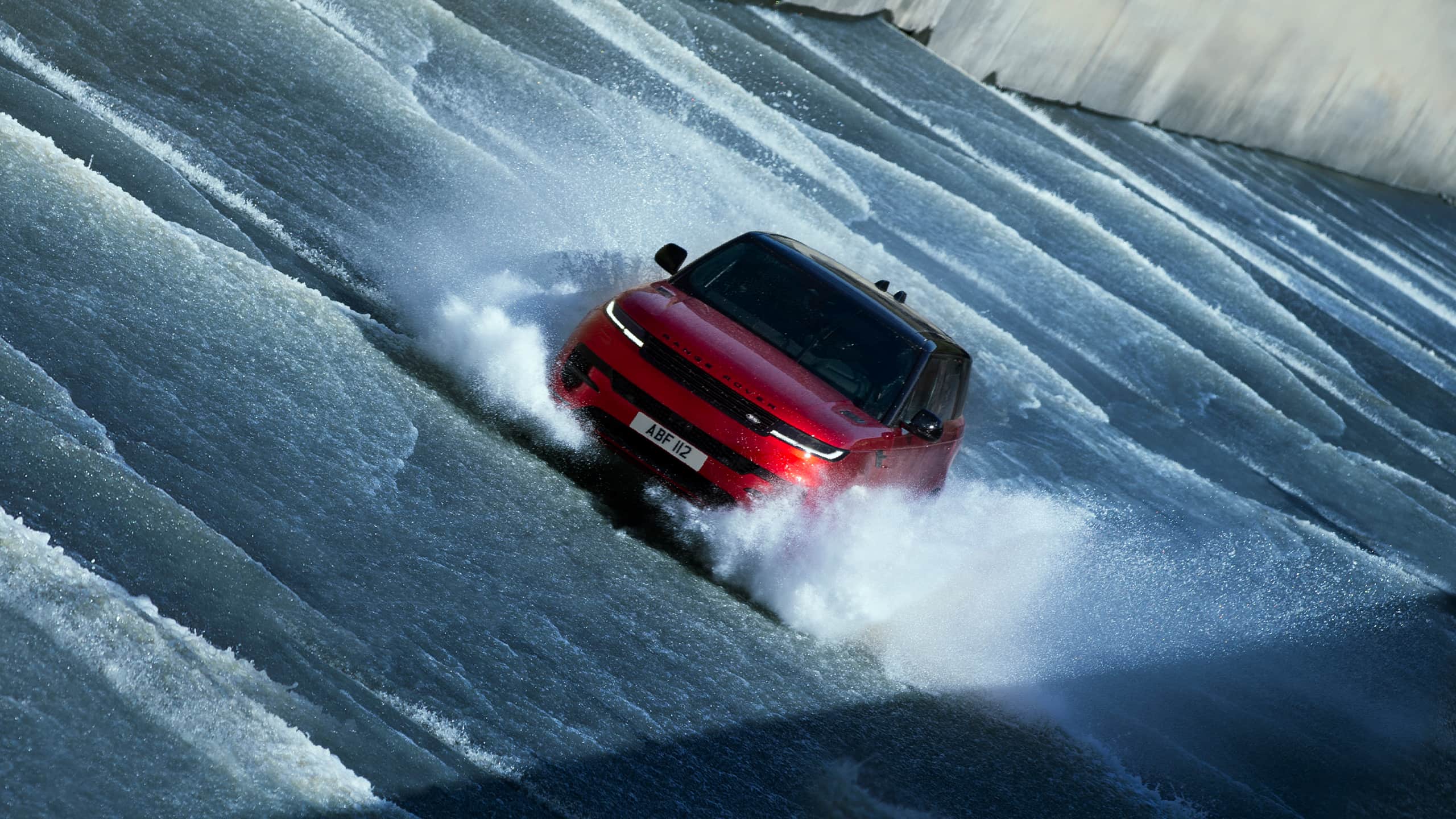 Red Range Rover sport driving through water