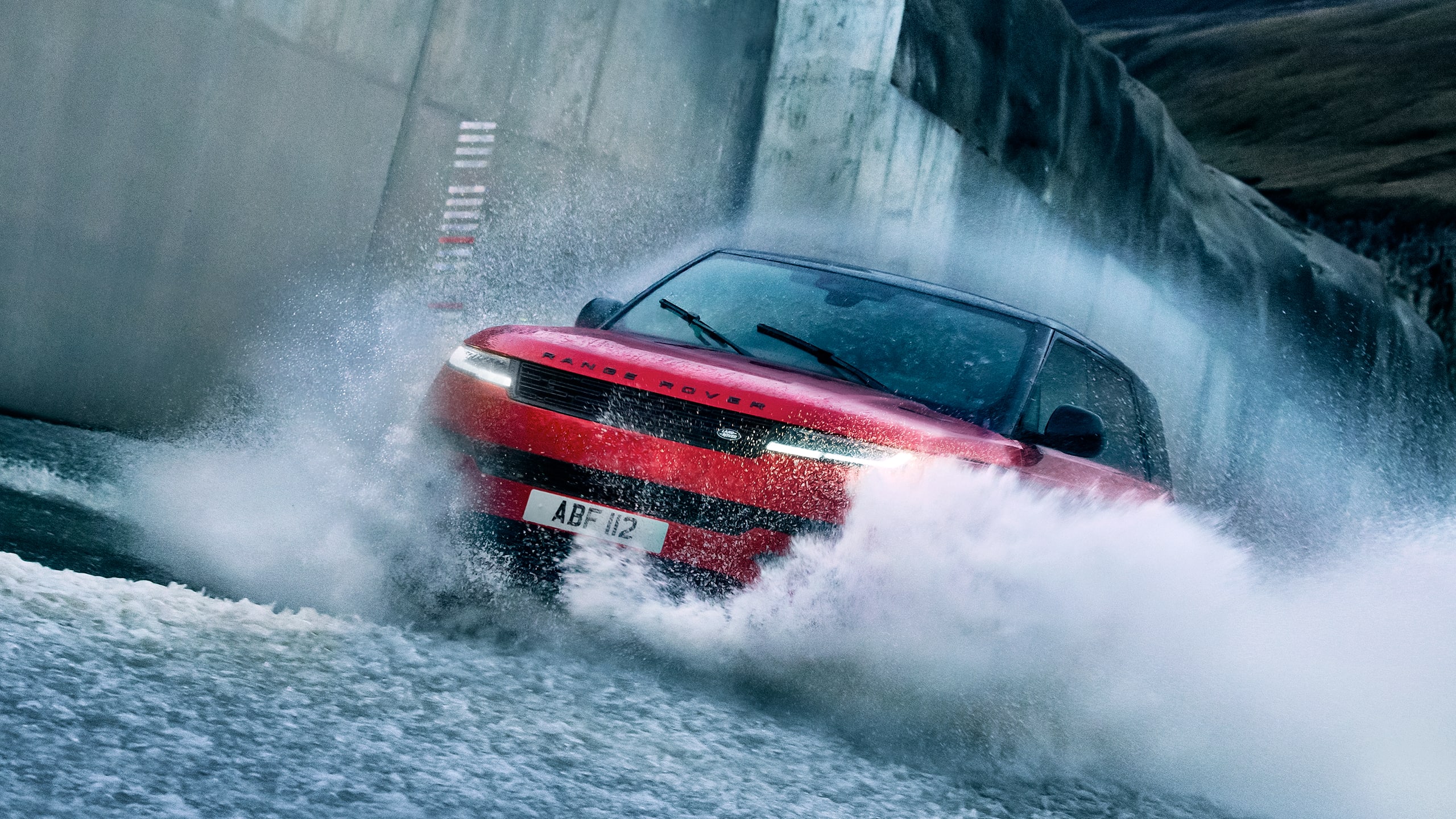 Range Rover Sport driving quickly through water on a flooded road