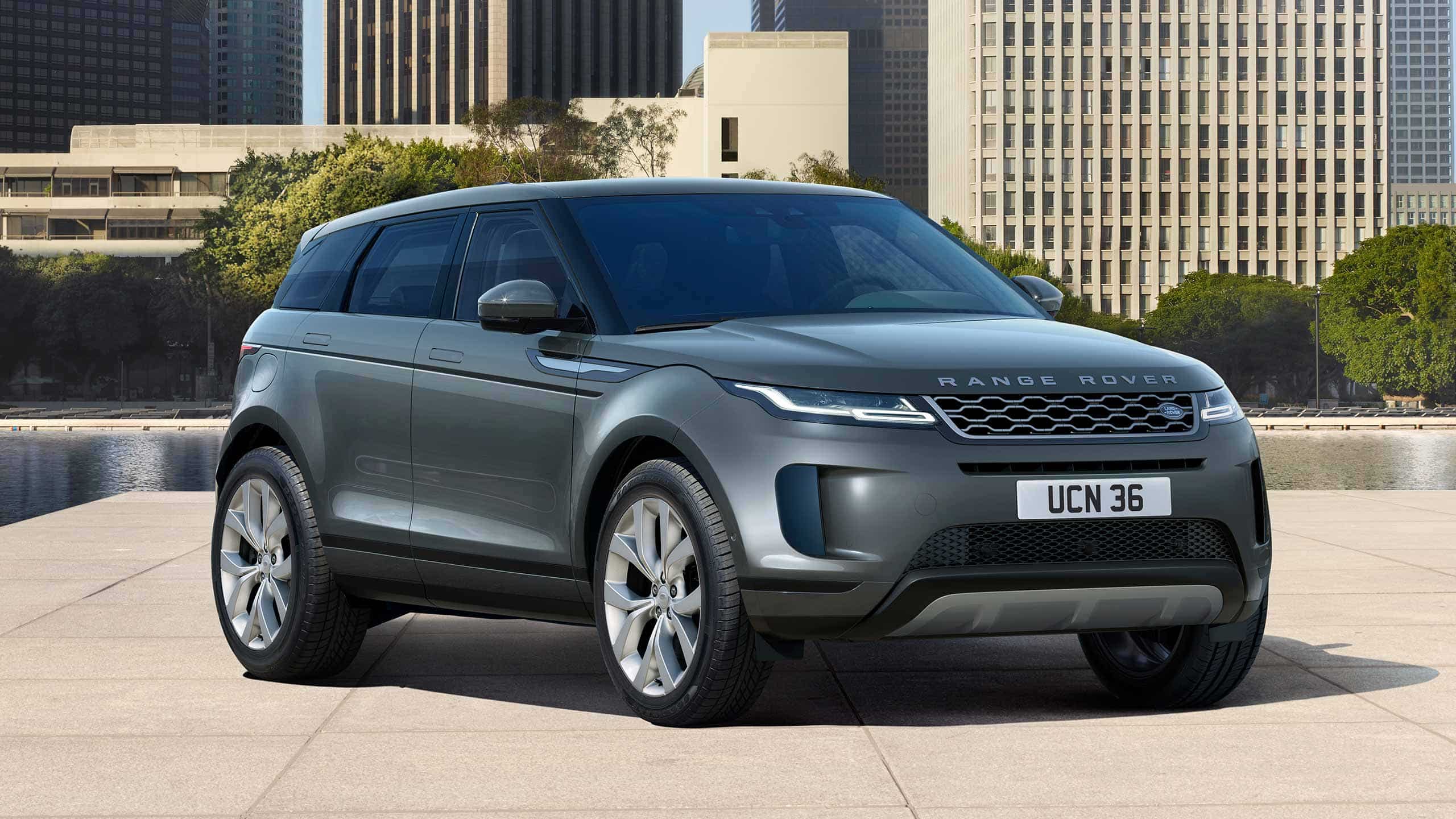 Evoque Parked By Garden Area Against Buildings In City