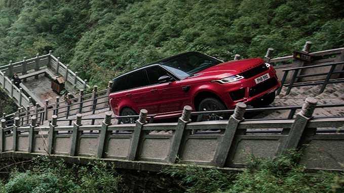 Red Range Rover driving uphill