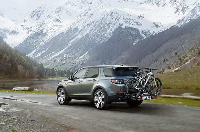 Range Rover with bike behind car and mountains surrounding
