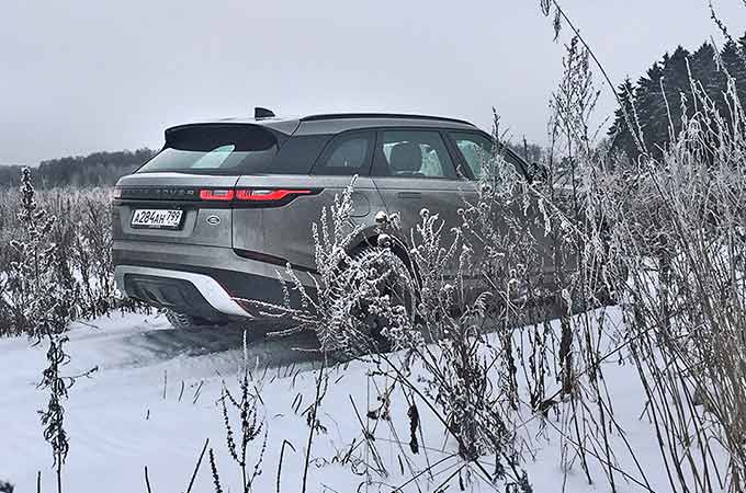 Grey Range Rover driving through the snow
